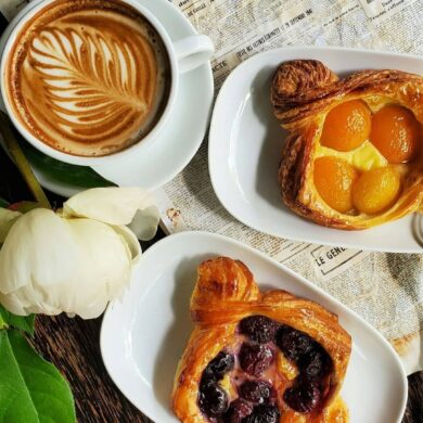 cappuchino and flower and baked goods on a table