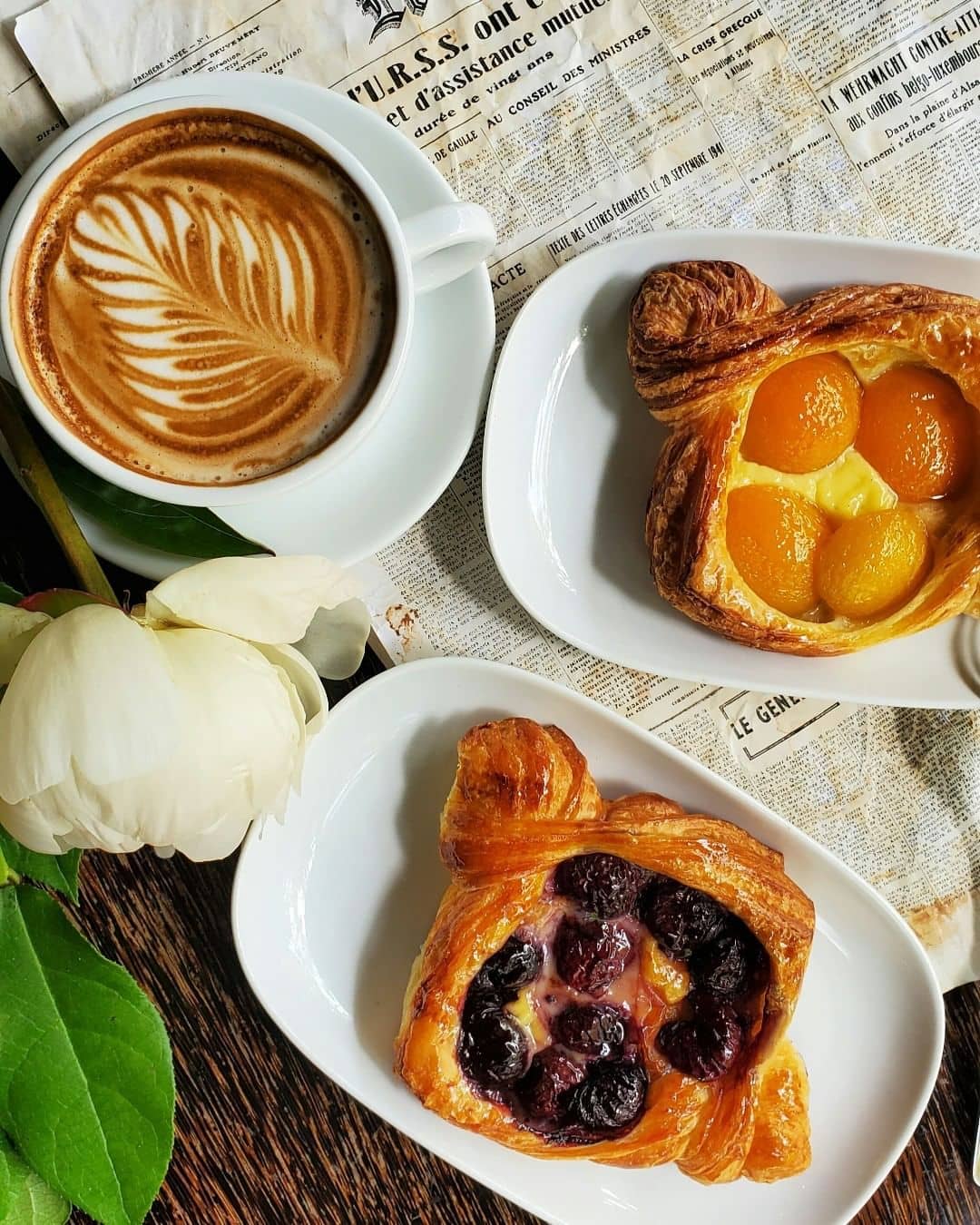 cappuchino and flower and baked goods on a table