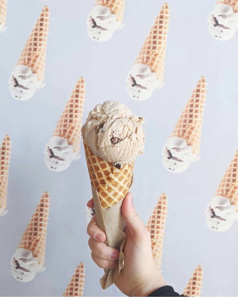 ice cream cone held infront of ice cream background