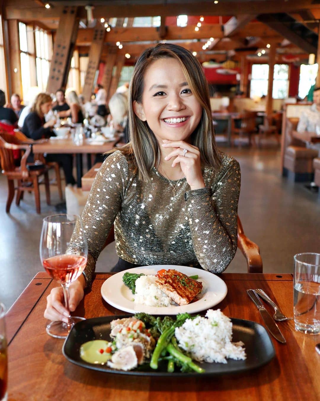 granville island neighbourhood guidebook - sandbar of girl smiling with food infront of her on the table