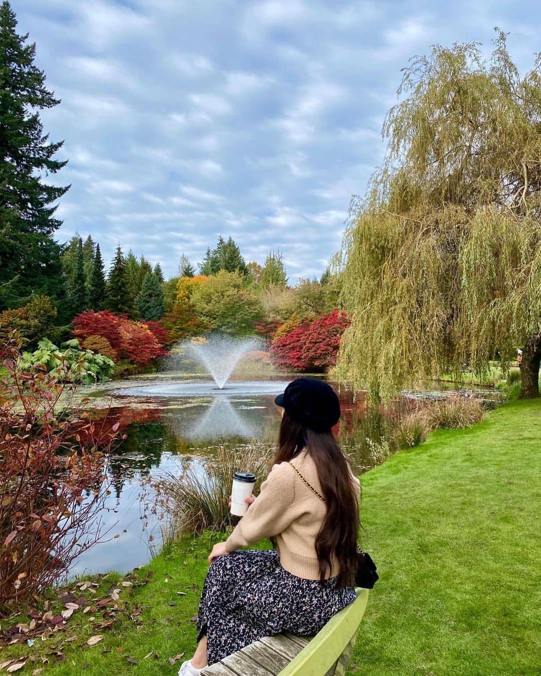 best parks - van dusen gardens with girl sitting on bench looking at water fountain