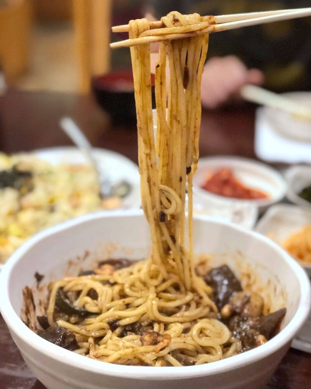 best korean restaurant in richmond - dai jang kum picking up noodles from bowl with chopsticks