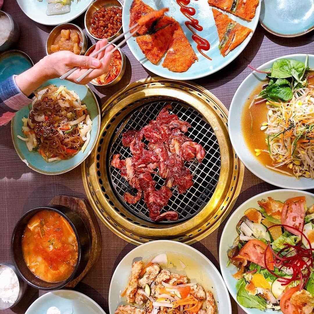best korean restaurant in richmond - sura richmond meat on grill and plates of food on table
