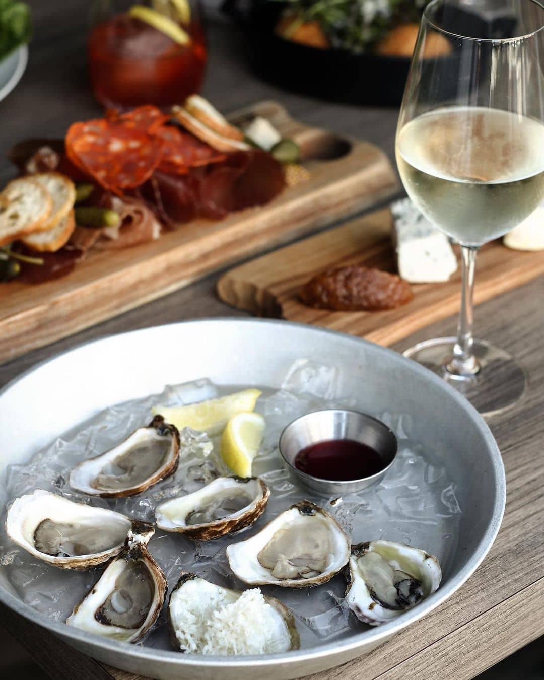 best squamish restaurants - salted vine oysters on ice and wine glass