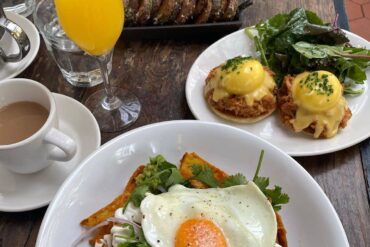 egg benedicts and mimosa on table best yaletown brunch spots - homer st. cafe