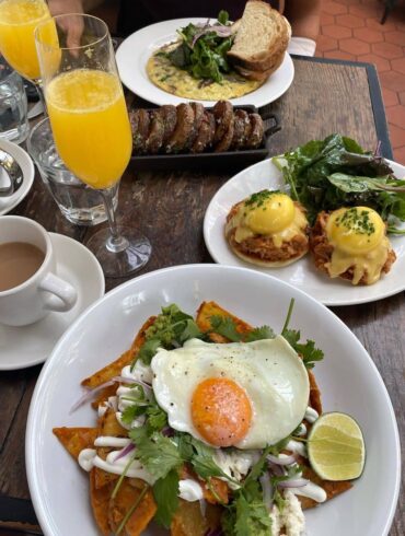 egg benedicts and mimosa on table best yaletown brunch spots - homer st. cafe