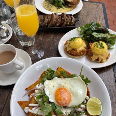 egg benedicts and mimosa on table best yaletown brunch spots - homer st. cafe