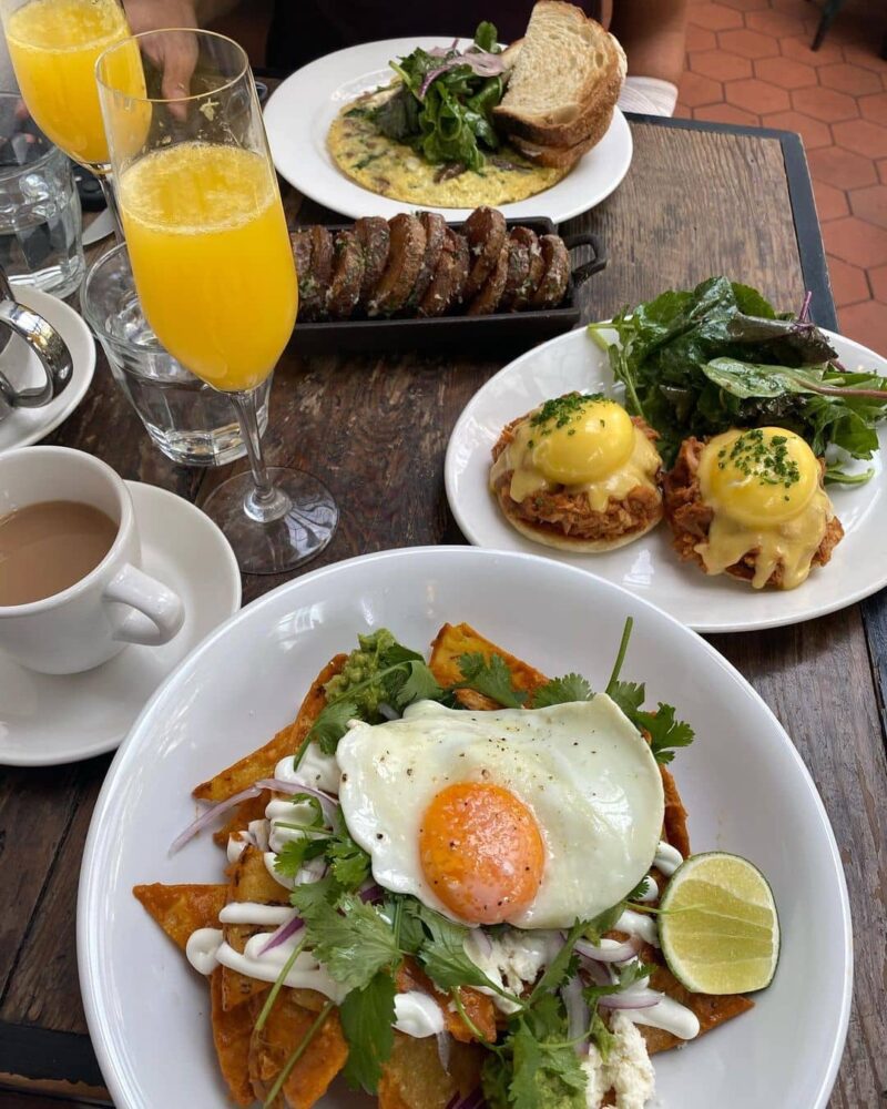 egg benedicts and mimosa on table best yaletown brunch spots - homer st. cafe